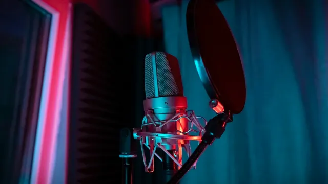 Studiomikrofon mit Poppschutz in rotem und blauem Licht – sexy Stimme am Telefon